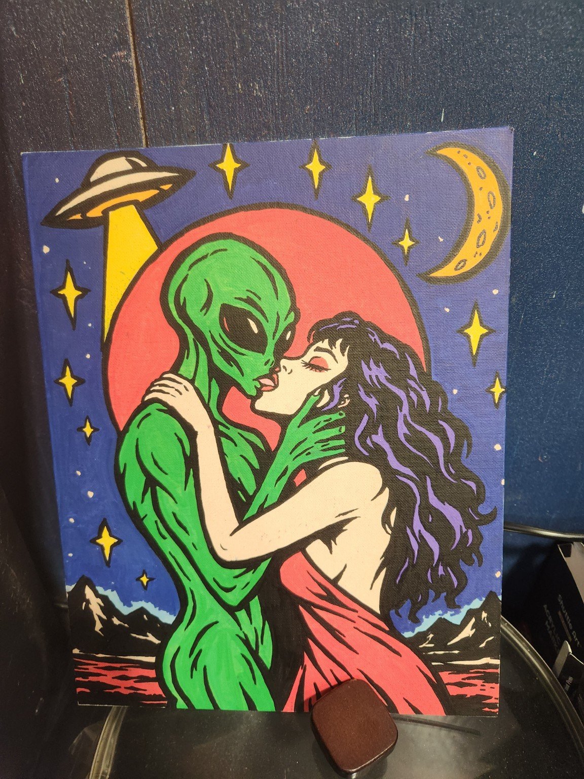 Alien and woman embracing beneath a UFO, stars and moon